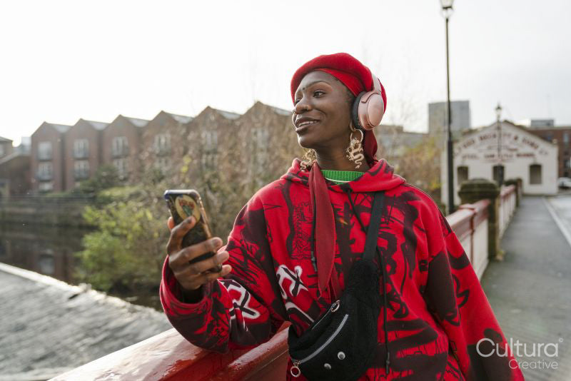Young woman standing on bridge and using phone