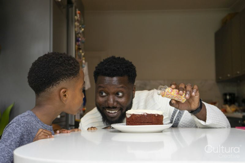 Father and son preparing birthday cake