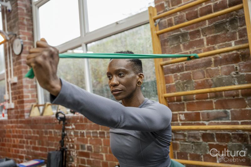 Athletic woman exercising with resistance band at gym