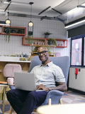 Man using laptop in office cafeteria
