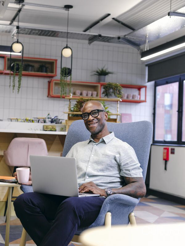 Man using laptop in office cafeteria