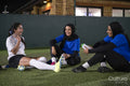 Female soccer players sitting and laughing