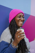 Beautiful woman holding coffee cup in front of colorful background