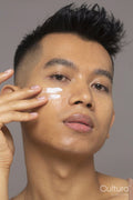 Studio portrait of person applying moisturizer on face