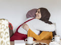 Female friends embracing at home