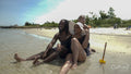 Smiling parents with son sitting on beach