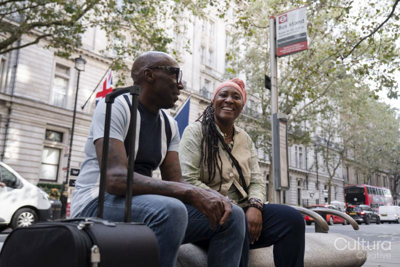 Happy mature couple sitting at bus stop