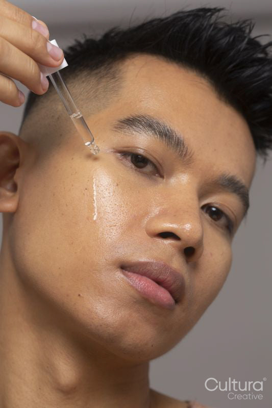 Close-up of person applying serum on face