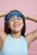 Studio portrait of smiling girl wearing sun visor