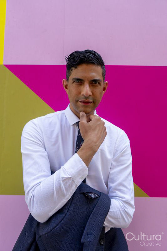 Portrait of businessman standing against colorful wall