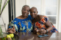 Portrait of smiling senior woman with adult daughter at table