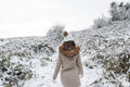 Rear view of woman walking in snowy landscape