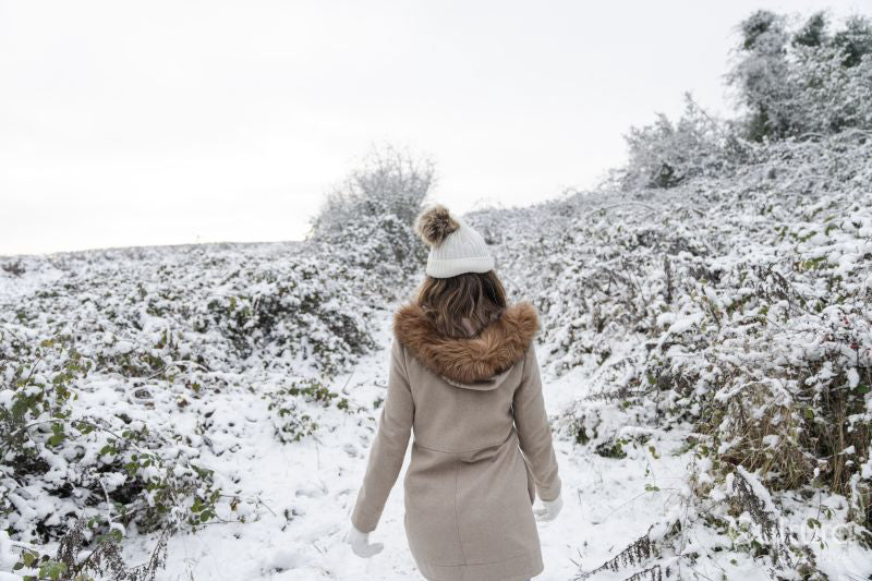 Rear view of woman walking in snowy landscape