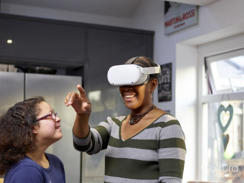 Girl with Down Syndrome looking at mother wearing VR goggles