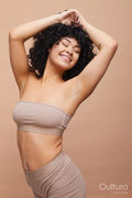 Studio portrait of beautiful happy woman with pierced belly button