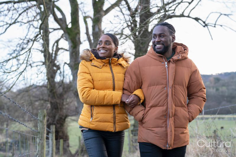 Couple in winter jackets walking in rural setting