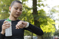 Athletic woman checking smart watch in park