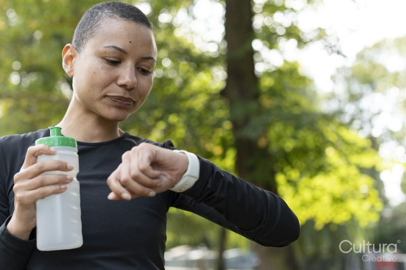 Athletic woman checking smart watch in park