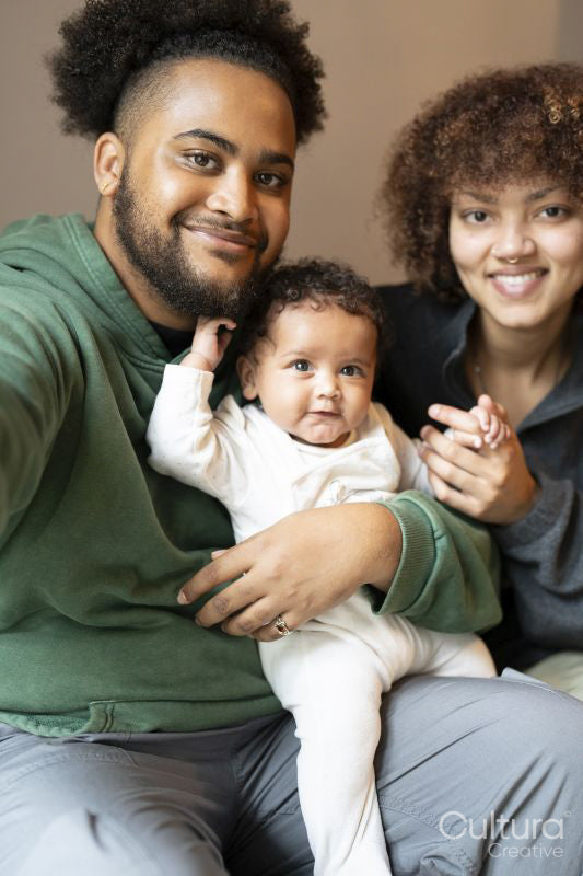 Smiling parents with baby daughter at home