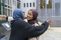 Two young women meeting in city