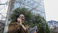 Woman using phone outside office building