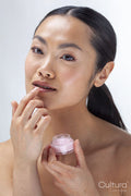 Studio portrait of woman applying lip balm