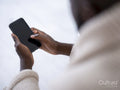 Close-up of person wrapped in blanket holding smart phone