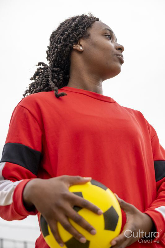 Athletic woman with soccer ball outdoors