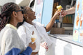 Young female friends buying ice cream in ice cream truck