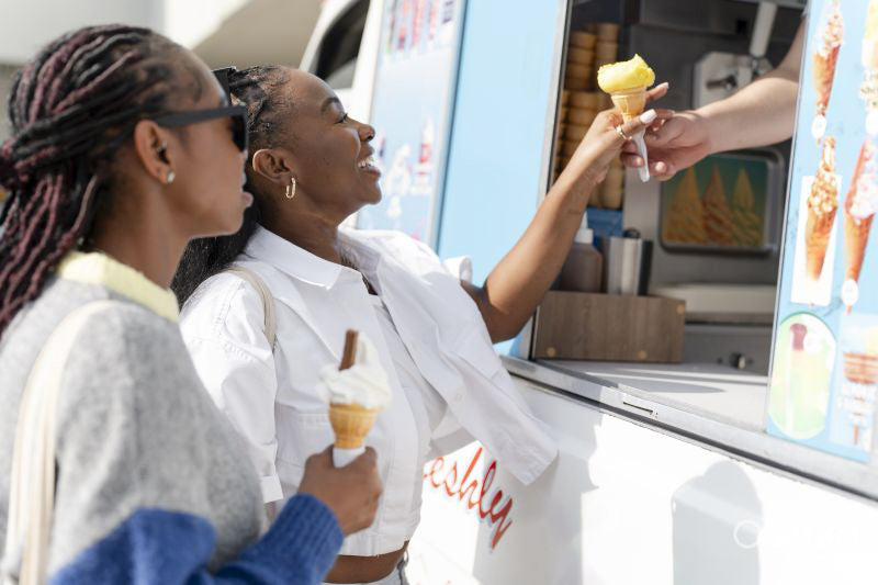 Young female friends buying ice cream in ice cream truck