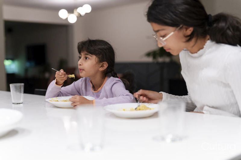 Sisters eating meal at table
