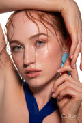 Studio portrait of a woman in a blue dress and large blue earrings