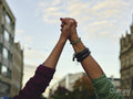 Two women holding hands up in air