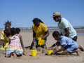 Family with children building sand castles on beach
