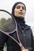 Portrait of woman in black sports clothing and hijab holding tennis racket