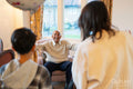 Happy senior man greeting daughter and grandson during visit in nursing home
