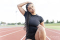 Female athlete stretching neck before run at stadium