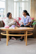 Senior woman knitting and talking to care giver in nursing home