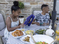 Siblings using tablet and smart phone at dinner table