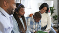 Family with children reading book at home
