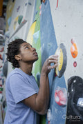 Young woman climbing on bouldering wall