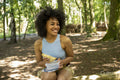 Young woman eating snack in forest