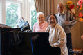 Senior people singing at piano in nursing home