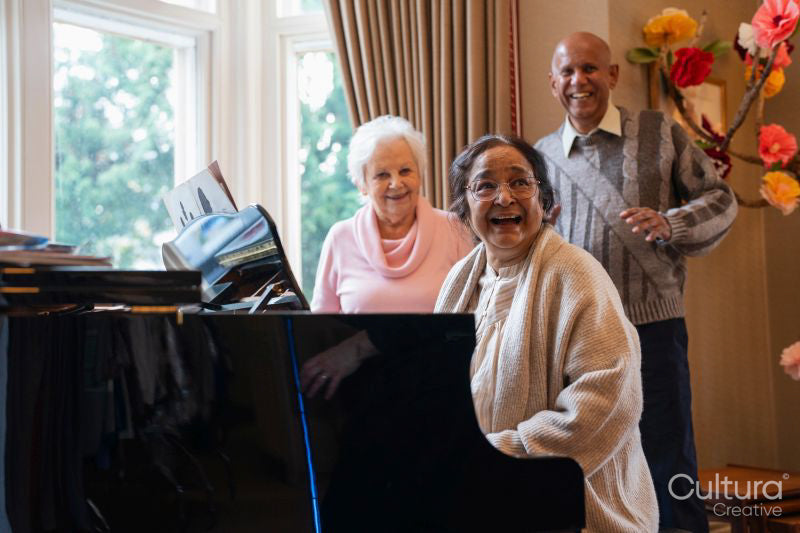 Senior people singing at piano in nursing home