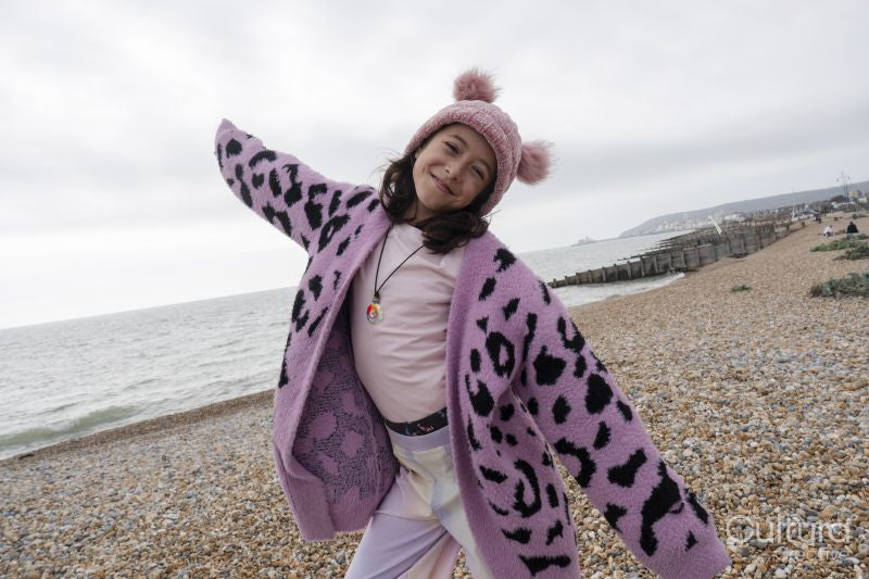 Portrait of girl standing with arms outstretched on beach