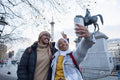Young female tourists in hijabs taking selfie in Trafalgar Square
