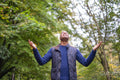 Smiling man standing in forest and looking up