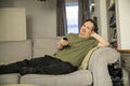 Man sitting on sofa and using remote control