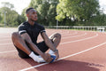 Athlete stretching legs before training at sports track
