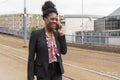 Businesswoman talking on phone while walking on city street